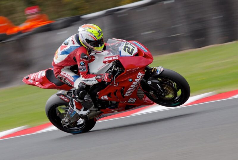 A motorcycle racer leaning into a high-speed turn on a racetrack