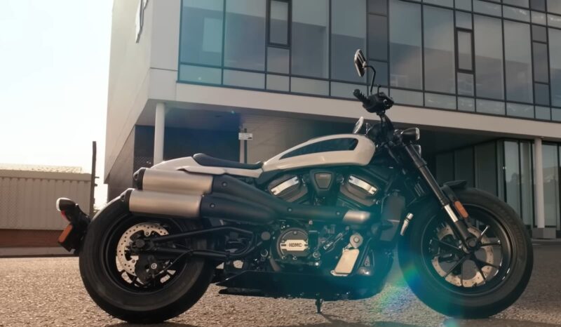 A Harley Davidson Sportster parked outside a modern building
